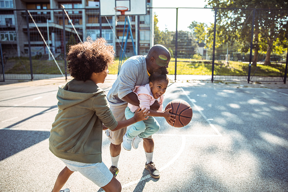 Cover image for Keeping Your Brain Healthy brochure: a father plays basketball with his young son and daughter